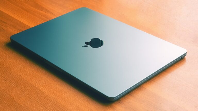 Apple notebook zavřený, dřevěný stůl
