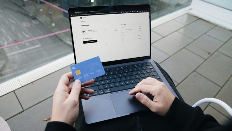 Notebook na klíně, platební karta a nákup na e-shopu
